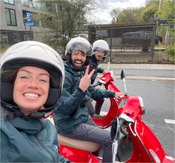 Three colleagues sitting on a scooter